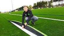 Der neue Reiselfinger Kunstrasenplatz ist fast fertig &ndash; wie Vorsitzender Stefan Kringe zeigt. Bild: Silvia Bächle