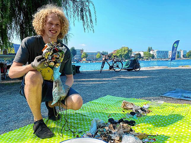 Janis Baur benutzt einen Magneten, um metallhaltigen Müll aus dem Fluss zu fischen.