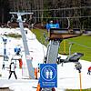 Mitte Januar in Ruhpolding: Skifahrer fahren bei schönem Wetter auf einer Skipiste &ndash; drumherum Wiese.