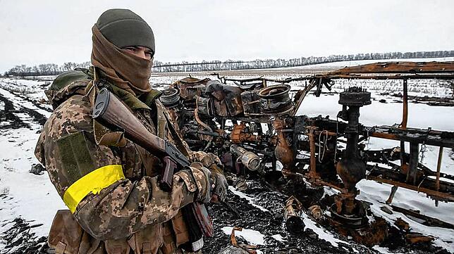 Ein ukrainischer Soldat neben einem ein zerstörten Militärfahrzeug an einem unbekannten Ort in der Ukraine.