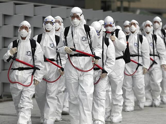 Coronavirus - Südkorea Soldaten der südkoreanischen Armee tragen Schutzkleidung und versprühen Desinfektionsmittel am Bahnhof Dongdaegu.