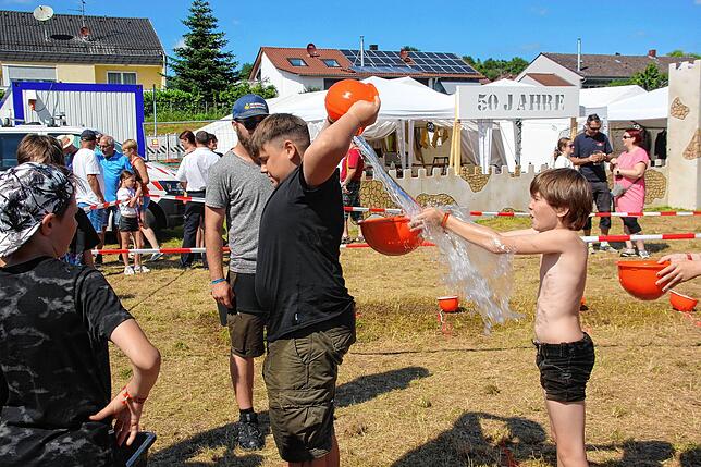 Das ging daneben: Die Wasserübergabe per Helm verfehlte so manches Mal das Ziel. Kalte Duschen nahmen die jungen Akteure gelassen hin.