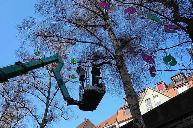 Beim Aufhängen der Holzblätter lässt sich die Mitarbeiterin der Firma Hainmüller in luftige Höhe fahren.