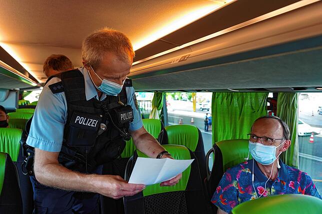 Bundespolizist Steffen Schuster kontrolliert das Covid-Zertifikat von einem Reisenden in einem Flixbus von Zürich nach München an der ...