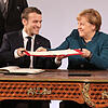 Emmanuel Macron und Angela Merkel tauschen den unterzeichneten Freundschaftsvertrag aus