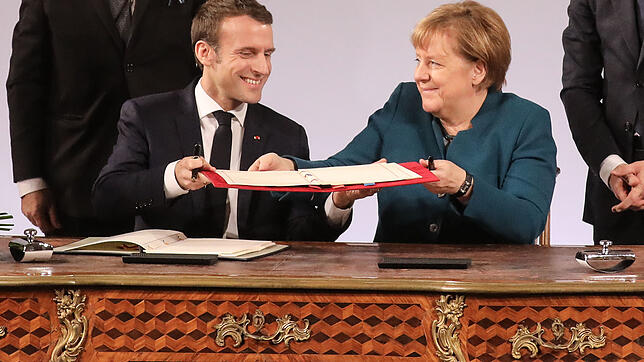 Emmanuel Macron und Angela Merkel tauschen den unterzeichneten Freundschaftsvertrag aus
