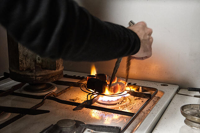 Viktor Kunz erhitzt die Kohle für eine Shisha auf offener Gas-Flamme.