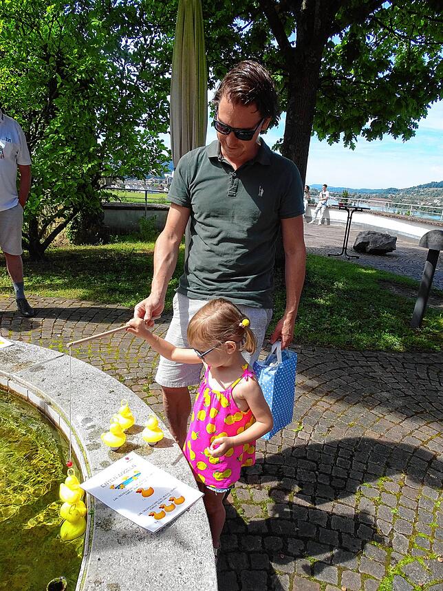 Frieda Wässerle (3) angelt mit Hilfe ihres Vaters Christian Enten aus einem Brunnen im Haberer Hof.