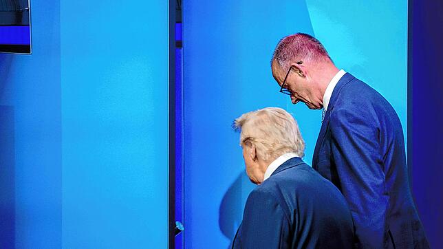 Bundeskanzler Friedrich Merz (CDU, r), und US-Präsident Donald Trump unterhalten sich beim Nato-Gipfel nach dem Familienfoto. Merz will ...