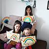 Liselotta (8 Jahre), Mieke (6 Jahre) und Tilda (2 Jahre) haben Regenbögen gemalt, die sie ins Fenster hängen.