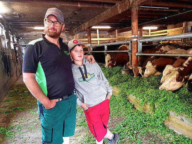 Stefan Leichenauer im Bullenstall mit seinem Sohn.