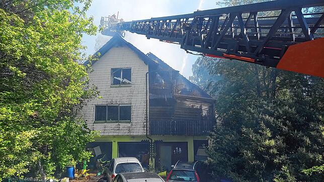 Feuerwehrleute bekämpfen von einer ausgefahrenen Leiter aus den Brand.