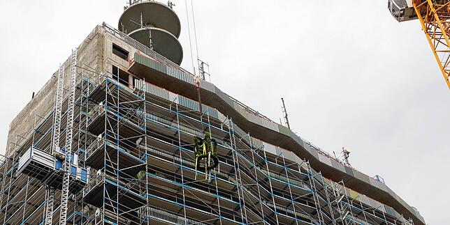 Als Zeichen dafür, dass das Projekt Telekomturm eine wichtige Etappe erreicht hat, baumelt am Kran eine große Krone aus Zweigen.
