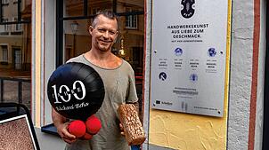 Manuel Beha vor seiner Bäckerei, neben der Ahnentafel.