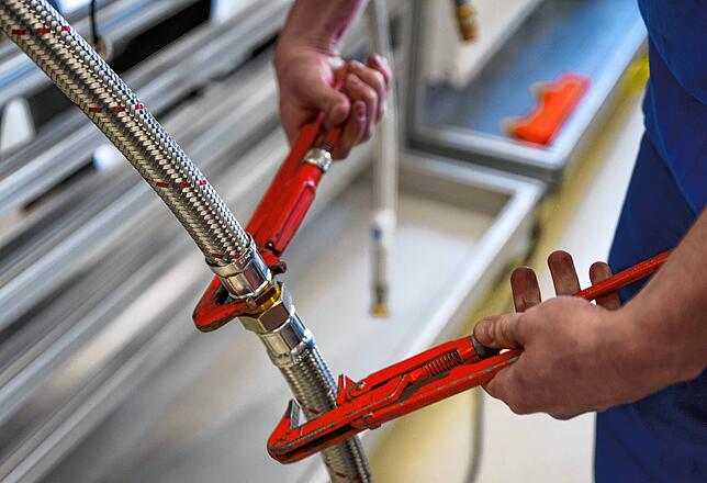 Ein Handwerker arbeitet an einer Heizung. Viele Betriebe langen bei der Installation von Heizungen zu. Kunden sollten kritisch ...
