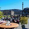 Eine Frau genießt das Sommerwetter in einem Café auf dem Stuttgarter Schlossplatz.