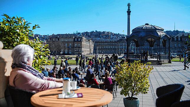 Eine Frau genießt das Sommerwetter in einem Café auf dem Stuttgarter Schlossplatz.