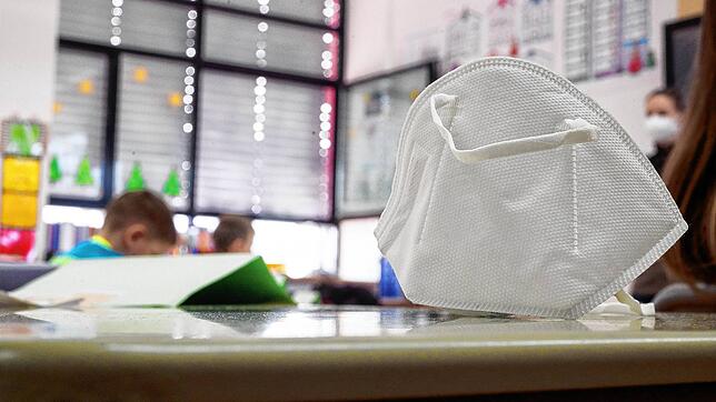 Eine FFP2-Maske liegt auf einem Tisch in einem Klassenzimmer. In den fünften und sechsten Klassen in Baden-Württemberg soll ab kommenden ...