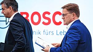 Stefan Grosch (rechts), Geschäftsführer und Arbeitsdirektor der Robert Bosch GmbH, verlässt nach einer Pressekonferenz über Stellenabbau ...