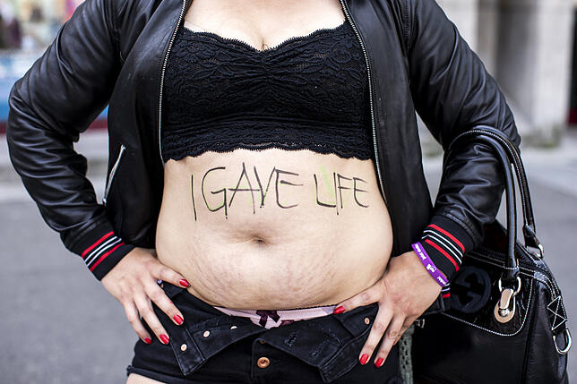 Eine Schweizer Mutter zeigt in Luzern ihren Bauch mit der Aufschrift „I gave life“ (Ich habe Leben gegeben).