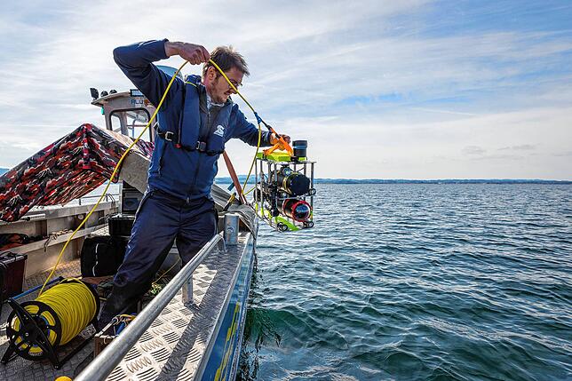 Silvan Paganini lässt einen der Unterwasserroboter in den Bodensee ein. Die kleinen Helfer können nicht nur aufklären, sonder auch ...
