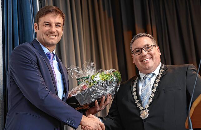 Landrat Zeno Danner (links) erhält von Bürgermeister Patrick Krauss einen Präsentkorb mit Leckereien der Vorderen Höri.