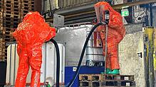 Mit entsprechender Schutzkleidung pumpt die Feuerwehr das Wasserstoffperoxid in einen unbeschädigten Behälter um.