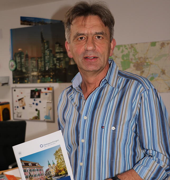 Andreas Dereck zeigt eine im Amt für öffentliche Ordnung erstellte Broschüre, die Vereinen hilft, Veranstaltungen zu planen.