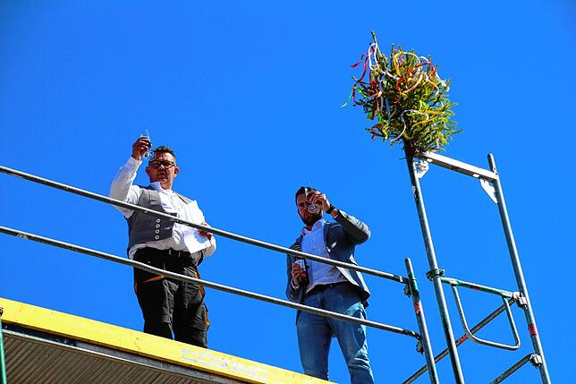 Sie stoßen mMit dem Richtspruch auf den gelungenen Rohbau an.