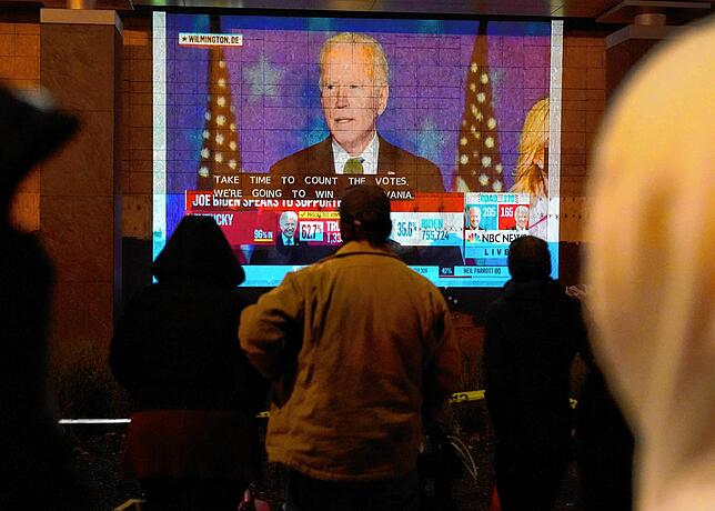 In Washington verfolgen Passanten in der Wahlnacht die Rede von Joe Biden