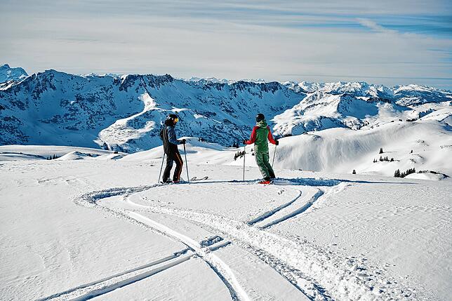 Ein Traum von Winter: Zwei Skifahrer betrachten die Berge im Skigebiet Damüls und Mellau.