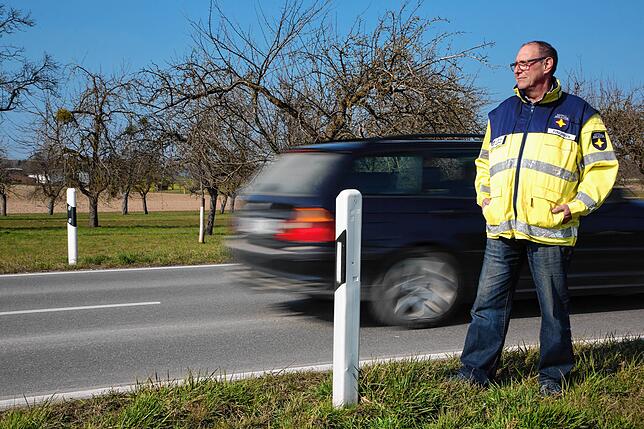 Notfallseelsorger Fritz Möhrle steht an einer Straße im Hegau, ein Auto fährt an ihm vorbei. Nicht selten wird er zu Unfällen mit ...