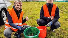 Ausbilderin Linda Sigg und Lukas Kramer, Auszubildender im dritten Lehrjahr, mit einem ganzen Eimer voller Kröten. Foto: Schöppeler