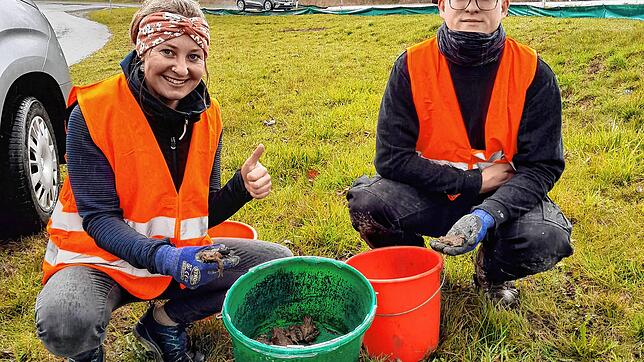 Ausbilderin Linda Sigg und Lukas Kramer, Auszubildender im dritten Lehrjahr, mit einem ganzen Eimer voller Kröten. Foto: Schöppeler
