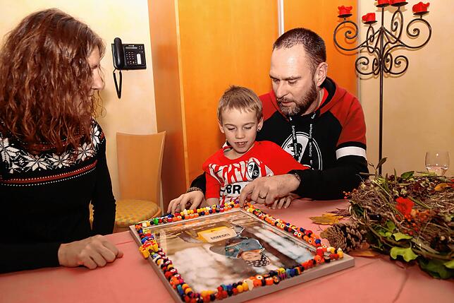 Bei der Reha für verwaiste Familien in der Nachsorgeklinik Tannheim befestigen Claudia, Tom und Hans-Peter Arzner (von links) Nicos ...
