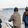 Symbolfoto: Ein Vater mit seinen beiden Söhnen bei schönem Wetter am Wasser.