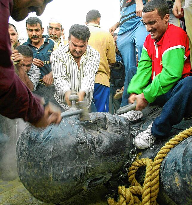 Iraker zerstören in Bagdad die Skulptur Saddam Husseins nach dessen Entmachtung 2003.