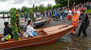 Haben sich nicht durch das Wetter ausbremsen lassen: Die Boote der Mooser Wasserprozession landen am Radolfzeller Ufer an. Hunderte ...