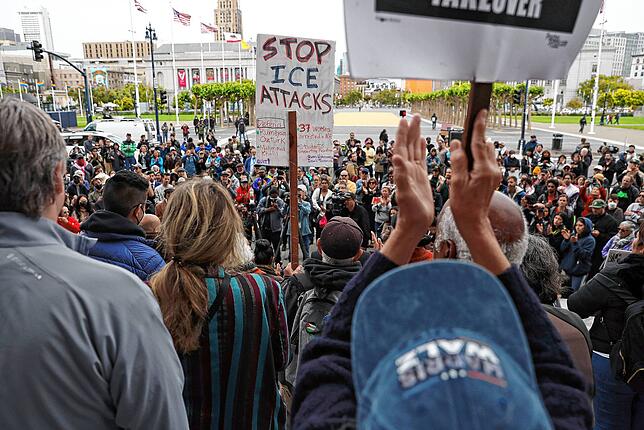 09.06.2025, USA, San Francisco: Demonstranten protestieren gegen die Einwanderungspolitik der US-Regierung bei einer Pressekonferenz auf ...