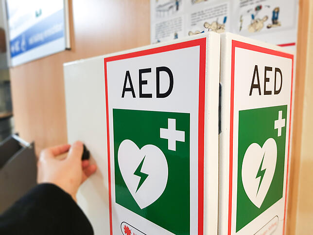 Wo sich Defibrillationsgeräte befinden ist an diesen Schildern zu erkennen.