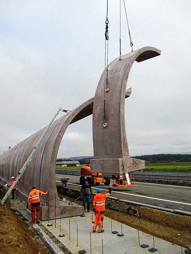 Stück für Stück setzen die Arbeiter entlang der Bundesstraße 27 bei Hüfingen die Teile für die neue Lärmschutzwand ein.