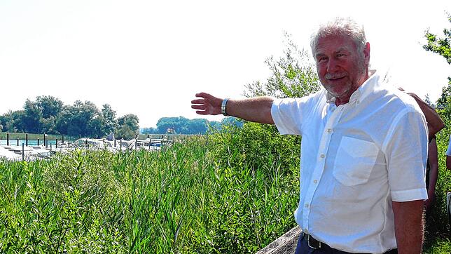 Paul Keller, Gemeindepräsident, zeigt auf die Stelle im See, wo die Entnahmeleitung für das Seewasser verlegt werden soll.