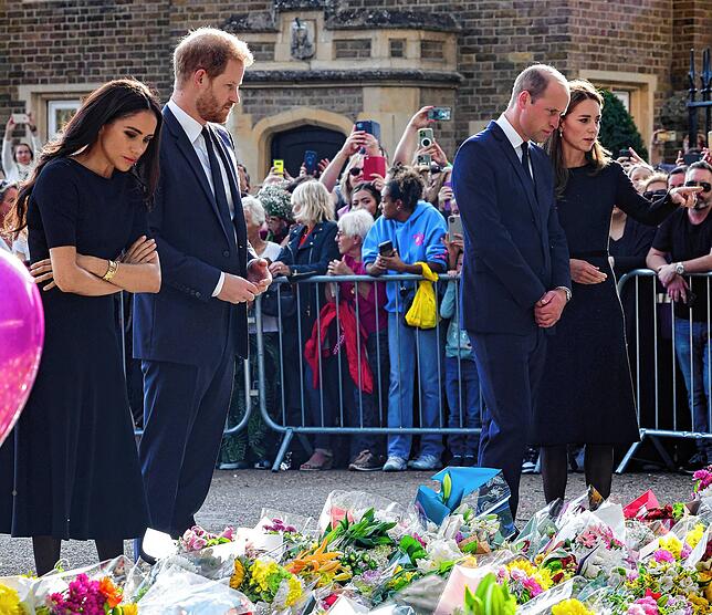 Die Vier betrachten die Blumen und letzte Grüße, die Trauernde auf Schloss Windsor nach dem Tod der Königin niedergelegt haben.