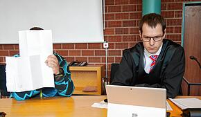 Am Tag des Urteils vor dem Landgericht Konstanz verbirgt André Rehm sein Gesicht hinter Akten. Neben ihm sitzt sein Anwalt Michael Busching.