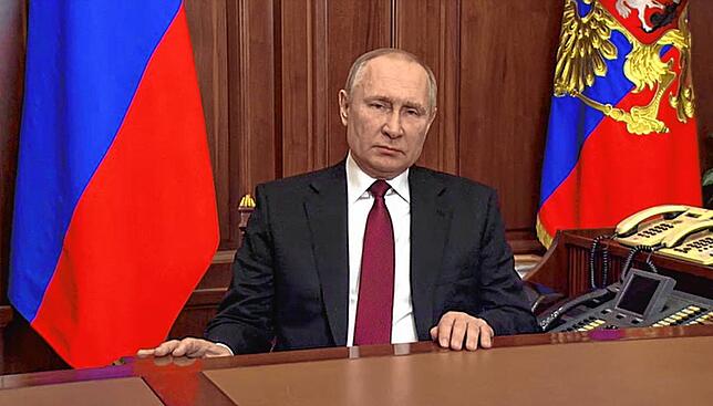 Dieses von der russischen Staatsagentur Tass verbreitete Bild, das aus einem Video gemacht wurde, zeigt Putin bei seiner Rede zur Invasion.