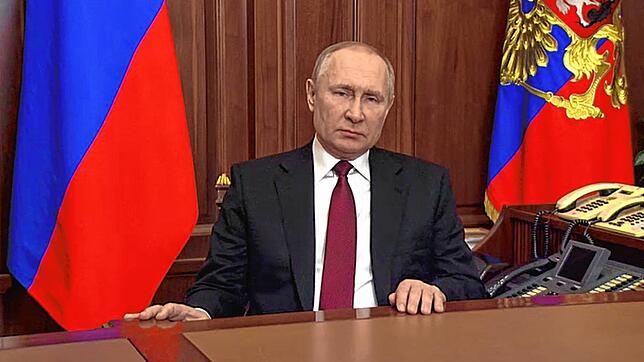 Dieses von der russischen Staatsagentur Tass verbreitete Bild, das aus einem Video gemacht wurde, zeigt Putin bei seiner Rede zur Invasion.