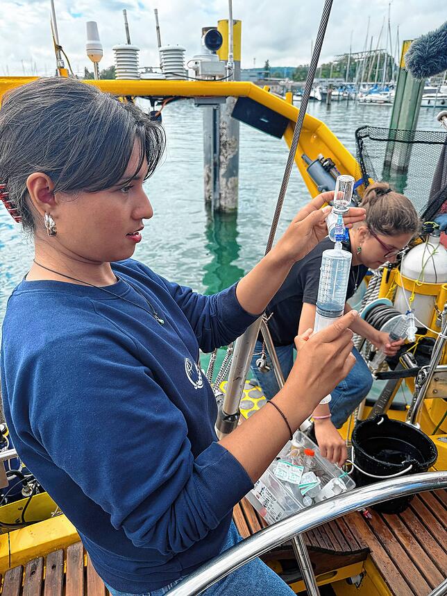 Karin Ritter (vorne) und Jaqueline Haußmann entnehmen Wasser aus dem See, um den Anteil von Klimagasen darin zu ermitteln.