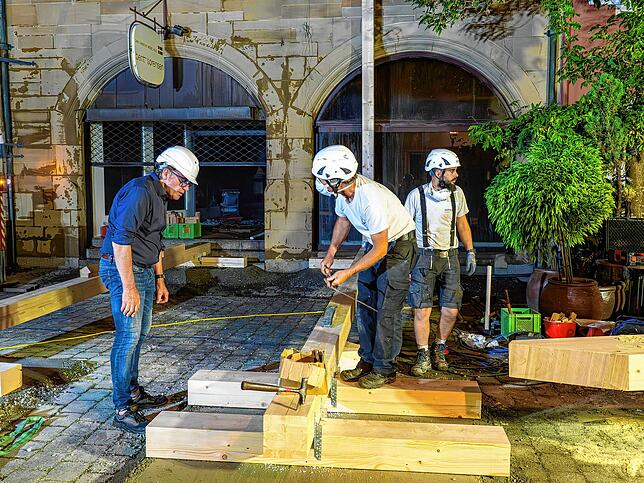 Zimmerleute, Architekt Christoph Bauer und Baustatiker Thomas Relling bauen eine Konstruktion, die die Fassade des Jugendstilhauses vor ...