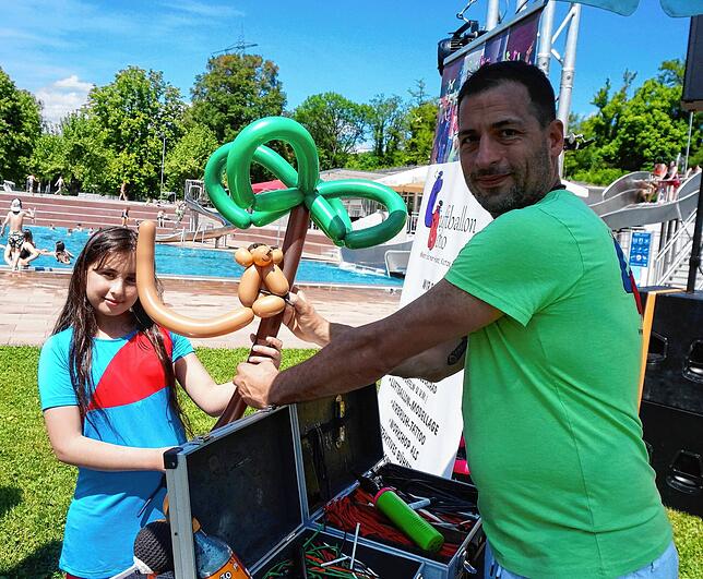 Besondere Angebote: Ballonfigurenhersteller Bino ist am Eröffnungstag für die Kinder da, hier überreicht er gerade der kleinen Rimas ...