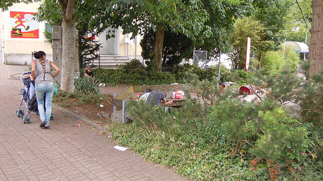 Am Waldshuter Busbahnhof sitzen Bettler vom Balkan, während eine Frau aus der gleichen Gruppe ihren Kinderwagen vorbeischiebt (Archivbild).